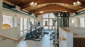 Une salle de sport équipée de tapis de course, de vélos elliptiques et de matériel de musculation.