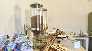 A kitchen counter with various food items, including jars of Carrefour yogurt, a coffee grinder, and a variety of cheeses and meats. - 38 Aira Hotels (Palermo)