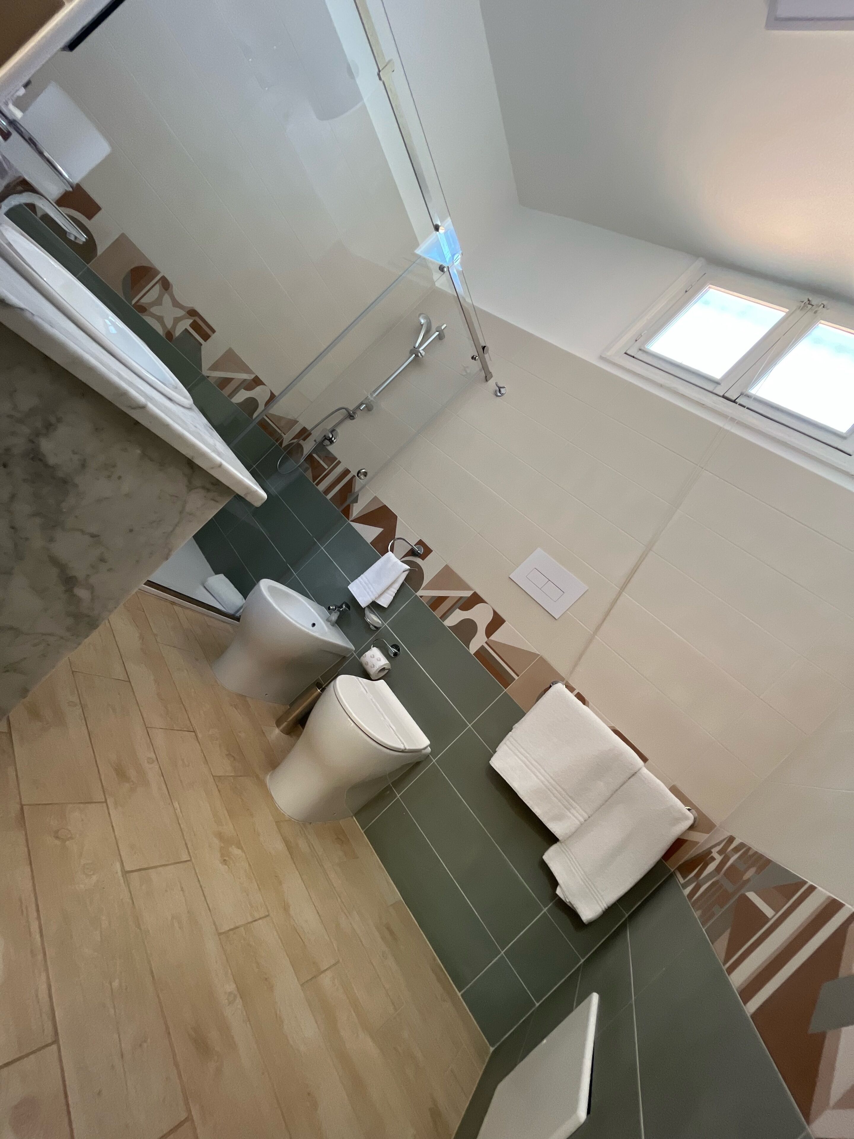 Ein Badezimmer mit Toilette, Waschbecken und Duschbereich.