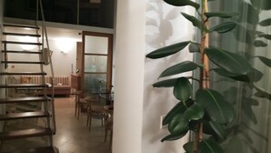 A room with a wooden ladder, a table with chairs, and a large green plant. - La Residenza Il Maggio B&B (Florence)