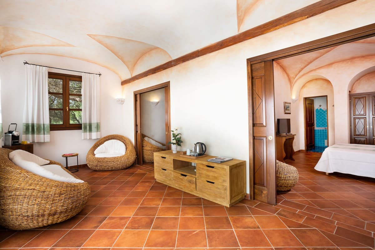 Ein geräumiger Raum mit einem Holzkasten, Korbmöbeln und einem Bett.