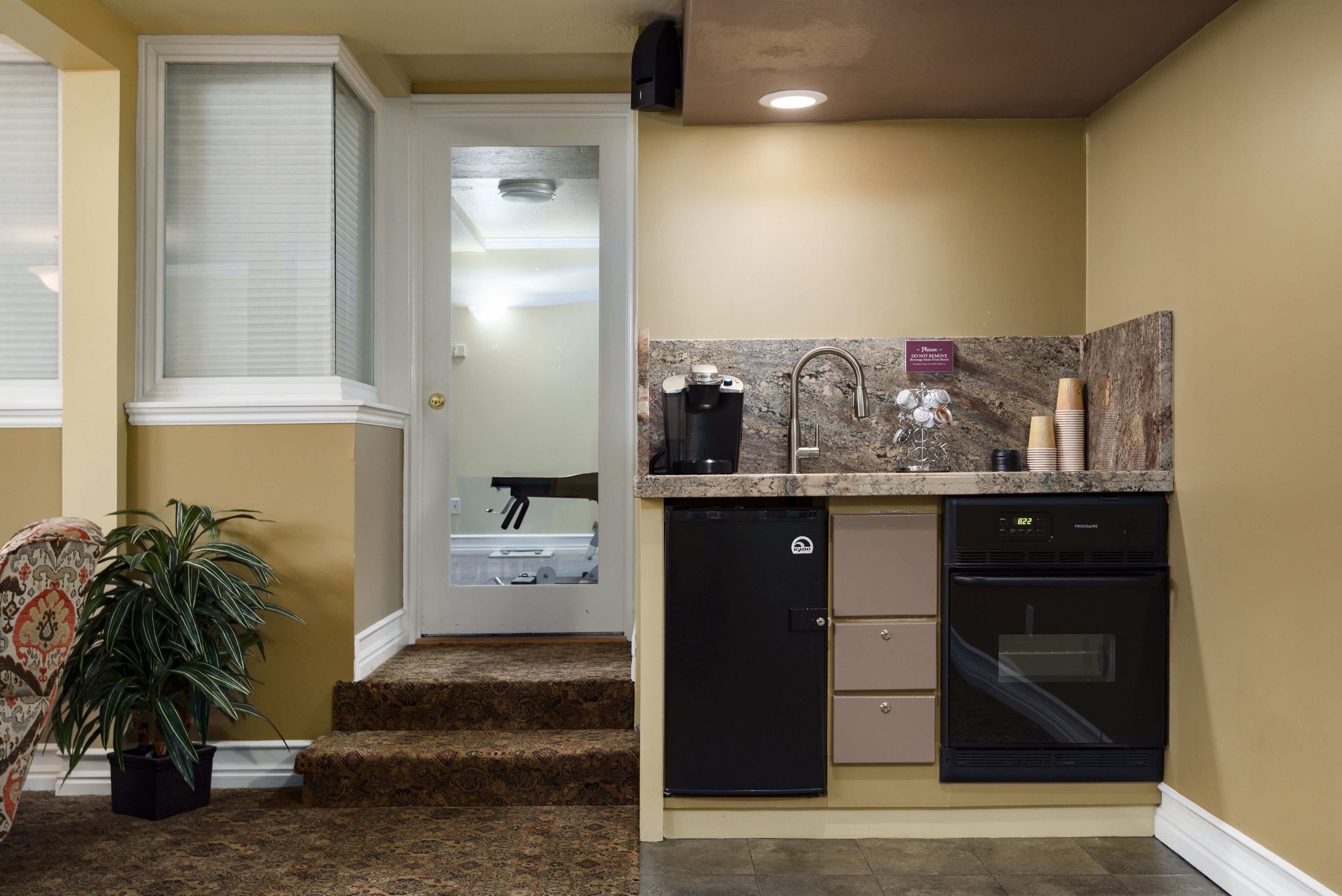 A compact kitchen with a built-in dishwasher, a coffee maker, and a refrigerator.