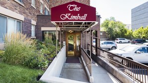 Un bâtiment doté d’un auvent rouge sur lequel on peut lire l’inscription « The Kimball », et d’une entrée abritée avec un banc.