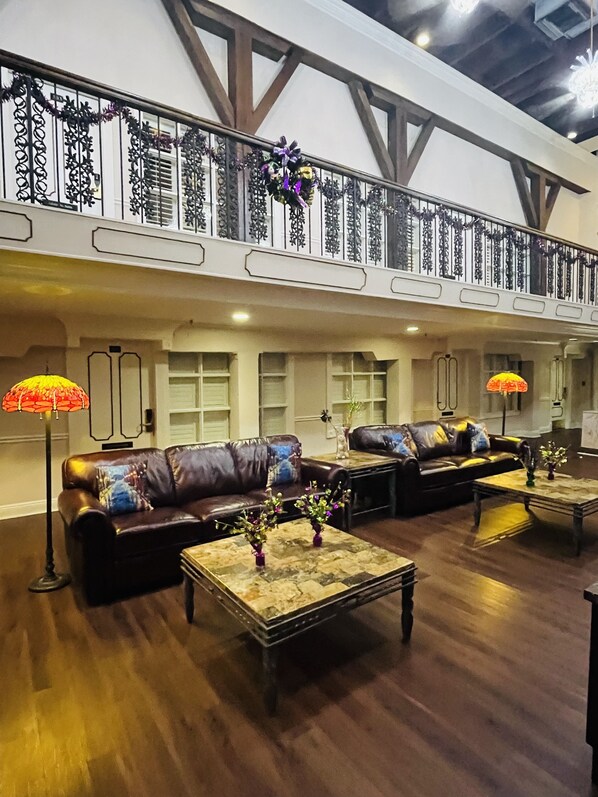 A spacious living area with leather sofas, wooden coffee tables, and decorative vases.