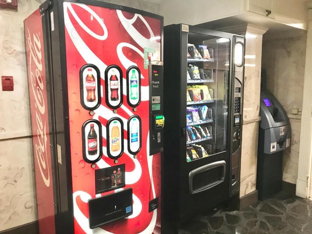 En Coca-Cola automat og en selvbetjeningsstander med forskellige varer.