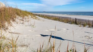A sandy beach with a wooden fence and dunes. - Windy Shores II (North Myrtle Beach)