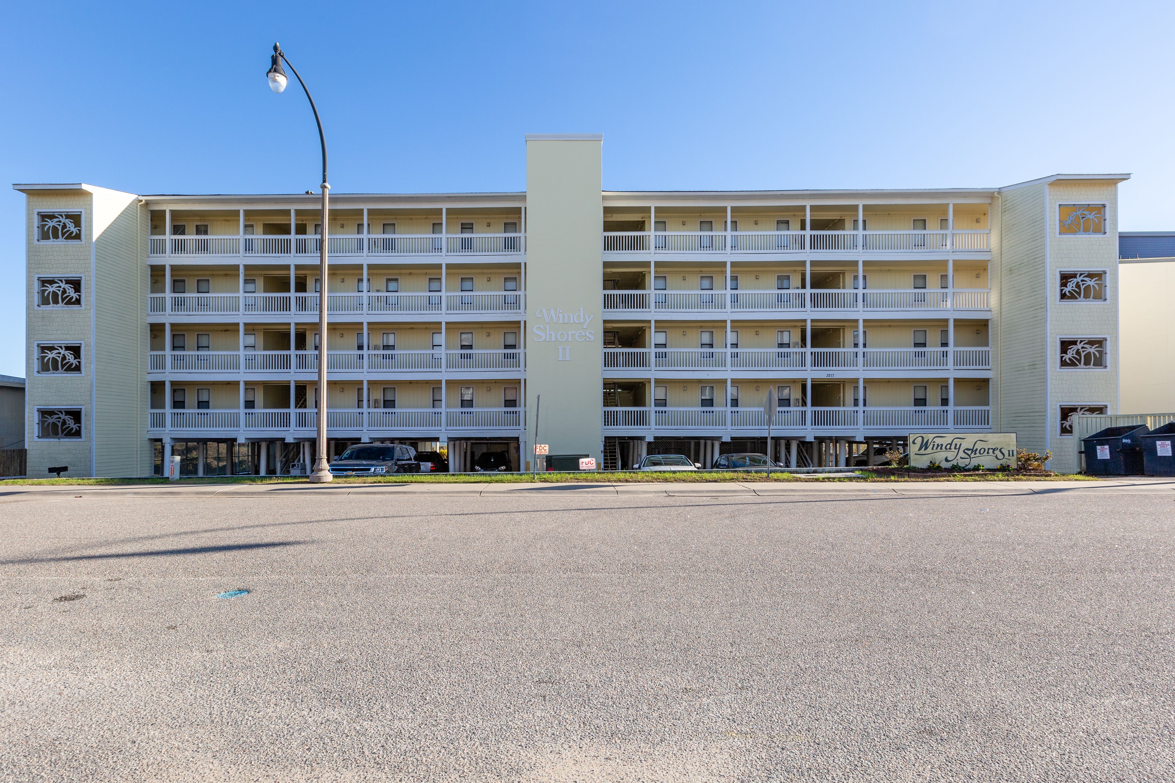 A multi-story hotel with a central tower, balconies, and a sign reading "Windy Shores II".
