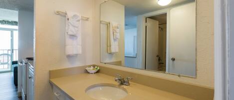 A bathroom with a sink, mirror, and towel rack.