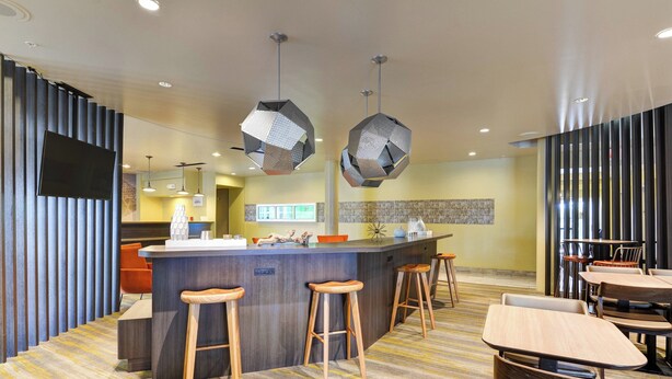 A modern bar area with a central island, bar stools, and hanging pendant lights. - SpringHill Suites Shreveport-Bossier City/Louisiana Downs (Bossier City)
