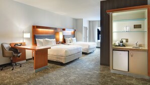 A hotel room with two beds, a desk, a chair, a mini-fridge, and a glass display cabinet. - SpringHill Suites Shreveport-Bossier City/Louisiana Downs (Bossier City)