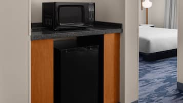 A compact kitchenette with a microwave and a built-in dishwasher.