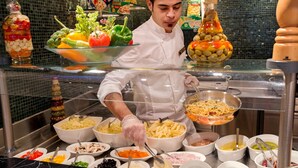 Una mesa de buffet con diversos alimentos y salsas.