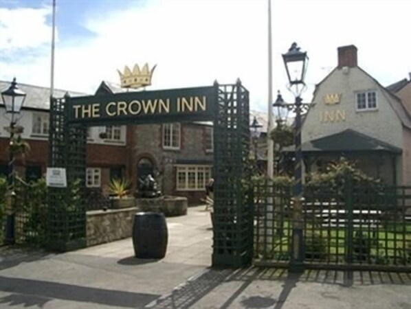 A traditional inn with a sign reading "The Crown Inn" and a crown symbol above the entrance.