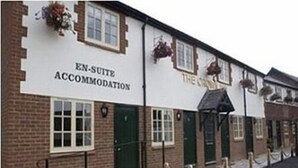 A building with a sign reading "EN-SUITE ACCOMMODATION" and "THE COTTAGE". - The Crown Inn (Swindon)