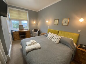 A bedroom with a bed, a desk, a chair, and a window. - Old Manse Hotel (Pickering)
