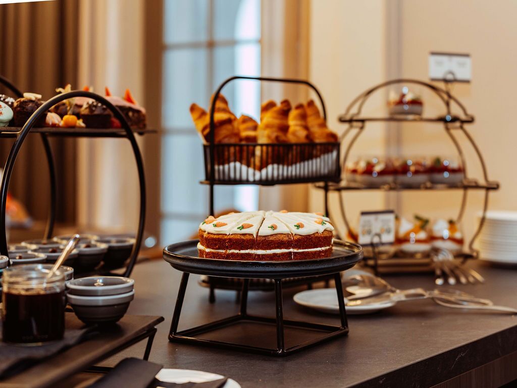 A buffet with various baked goods and desserts on display.
