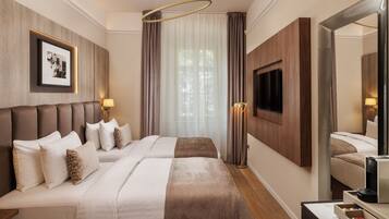 A hotel room with a large bed, a flat-screen TV mounted on the wall, and a mirror.