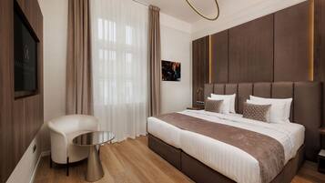 Una habitación de hotel moderna con una cama grande, una zona de estar y un televisor de pantalla plana.