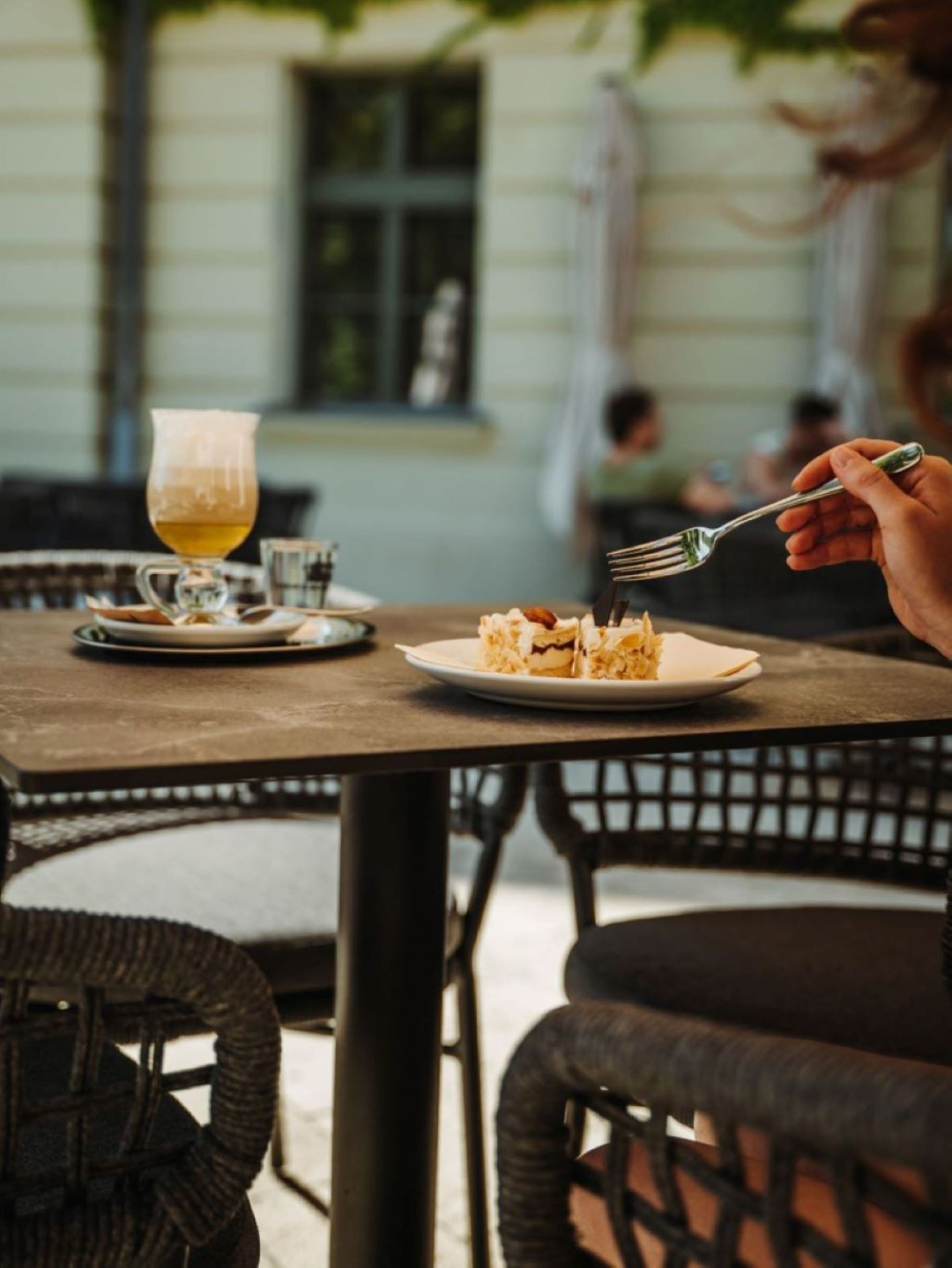 A dining table with a plate of food and a glass of a light-colored beverage.