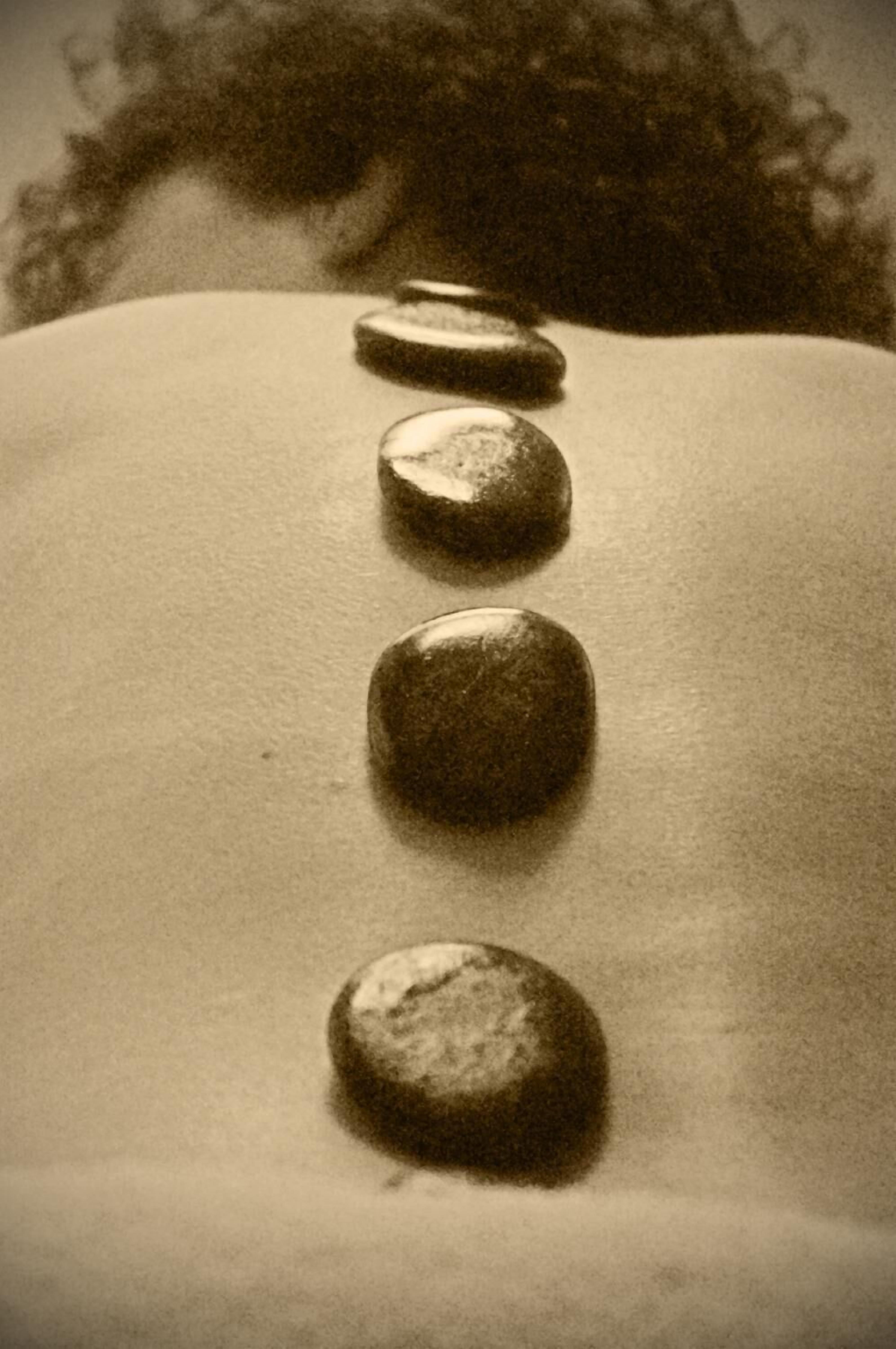 A row of smooth, round stones on a textured surface.