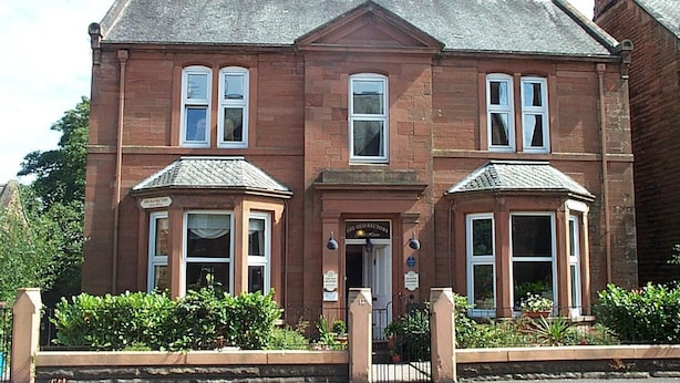 A two-story brick building with a symmetrical facade, large windows, and a central entrance. - The Old Rectory (Annan)