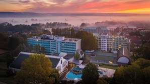 Ein Hotel mit mehreren Gebäuden, einem Schwimmbad und Blick auf die umliegende Landschaft.
