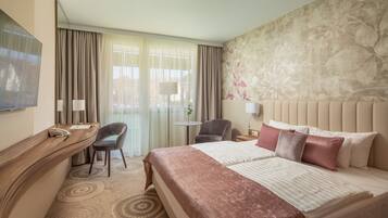 Une chambre d’hôtel avec un lit, un bureau, une chaise, une lampe et un téléviseur.