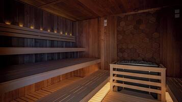 Una sala de sauna con bancos de madera y un revestimiento mural de diseño hexagonal.