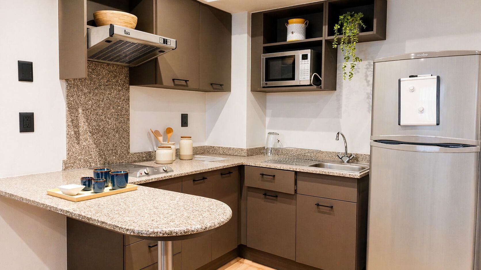 A modern kitchen with granite countertops, stainless steel appliances, and a built-in microwave shelf.