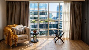 A modern living room with a sofa, a small round table with a plant, and a chair. - St Isidro Suites Corporate Housing SPA & Wellness Center (Mexico City)