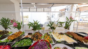 Un bufé con diversos platos y ensaladas.