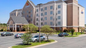 A Comfort Inn & Suites hotel with a parking lot, multiple cars, and a clear sky. - Comfort Inn & Suites Cordele (Cordele)