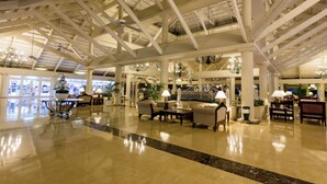 A spacious lobby with high ceilings, chandeliers, and comfortable seating areas.