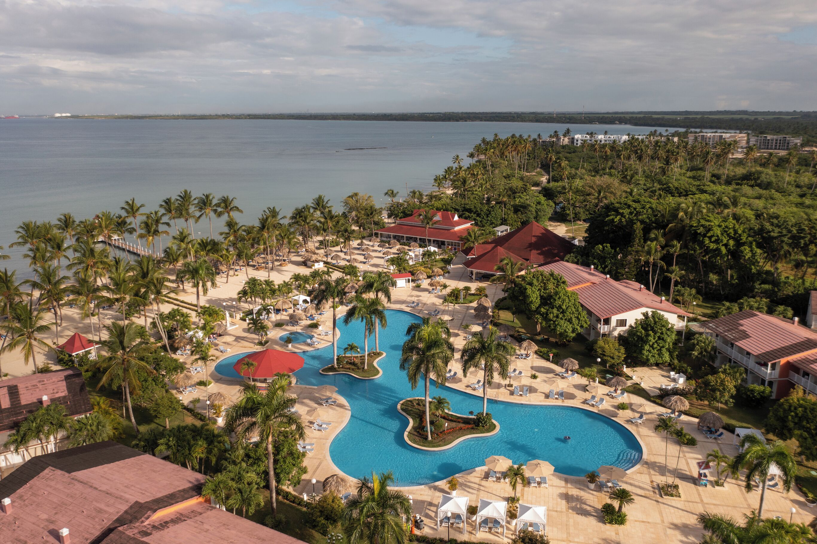 A resort with multiple swimming pools, palm trees, and beachfront views.