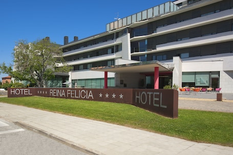 A modern hotel with a sign reading "HOTEL REINA FELICIA".