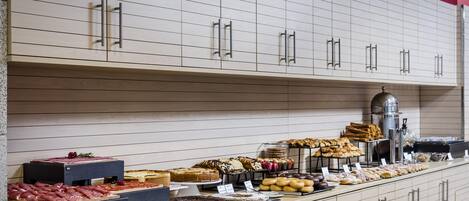 A buffet with various food items and a coffee machine.