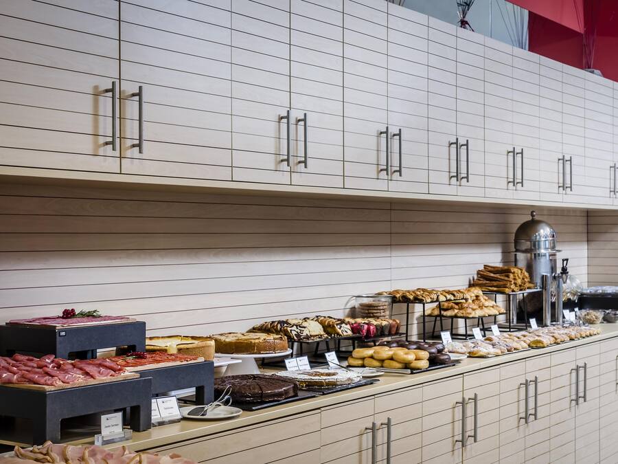 A buffet with various food items and a coffee machine.