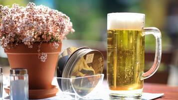 A beer mug, a terracotta pot with flowers, and a salt shaker on a table.