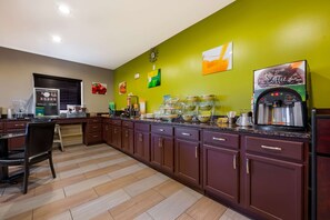 A kitchen with a coffee machine, a refrigerator, and various kitchen appliances.