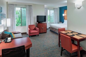 A hotel room with a bed, a TV, a desk with a telephone, a chair, a small cabinet, and a window with curtains. - Residence Inn by Marriott Chicago Lake Forest/Mettawa (Lake Forest)