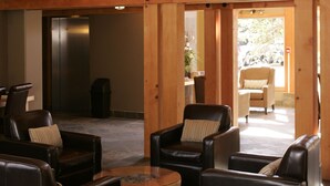 A spacious interior with wooden beams, leather sofas, and a chandelier. - Old House Hotel  (Courtenay)