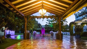 An outdoor covered patio with a tiled floor, a central decorative vase, and a wooden ceiling structure. - Cortijo Chico Málaga Airport (Alhaurin de la Torre)