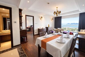A hotel room with a dining area, a bathroom, and a view of the sea. - Saigon Halong Hotel (Bai Chay)