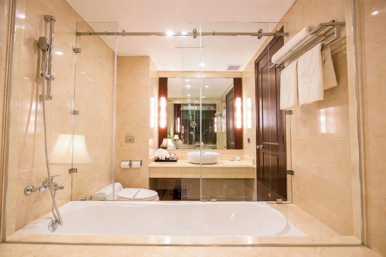 A modern bathroom with a glass-enclosed shower, a standalone bathtub, and a vanity with a mirror.