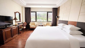 A hotel room with a large bed, a TV, a desk, and two armchairs. - Saigon Halong Hotel (Bai Chay)