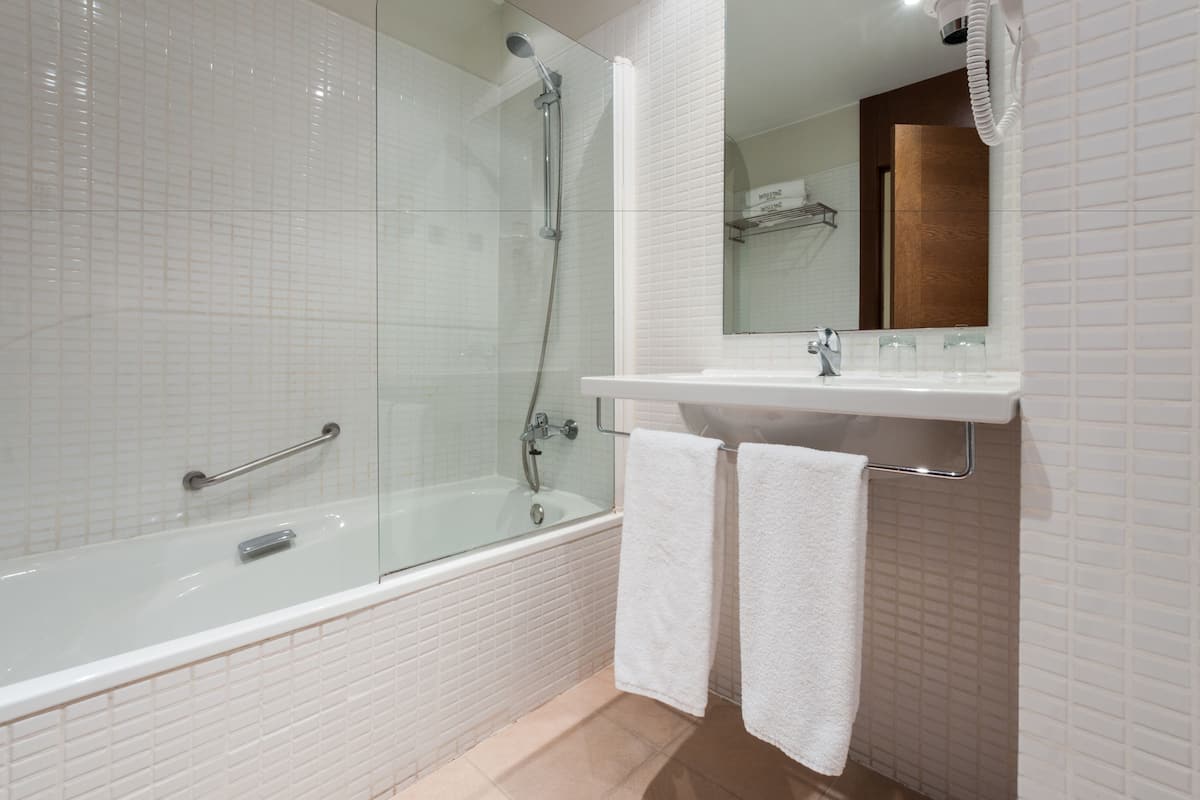 bathtub, eco-friendly toiletries, hair dryer, towels