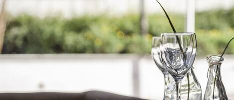 A table set with a wine glass, a small pitcher, and a fork on a placemat.