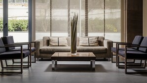 Una sala de estar moderna con un sofá, una mesa de centro y un jarrón alto.