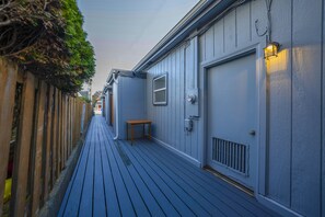 Guests can access the deck from this residential building, featuring a table and a door with a large window.