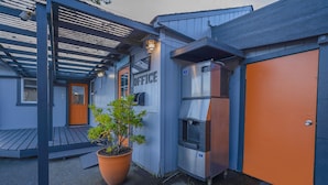 Un edificio con fachada azul, una puerta anaranjada y un letrero que dice "OFFICE".